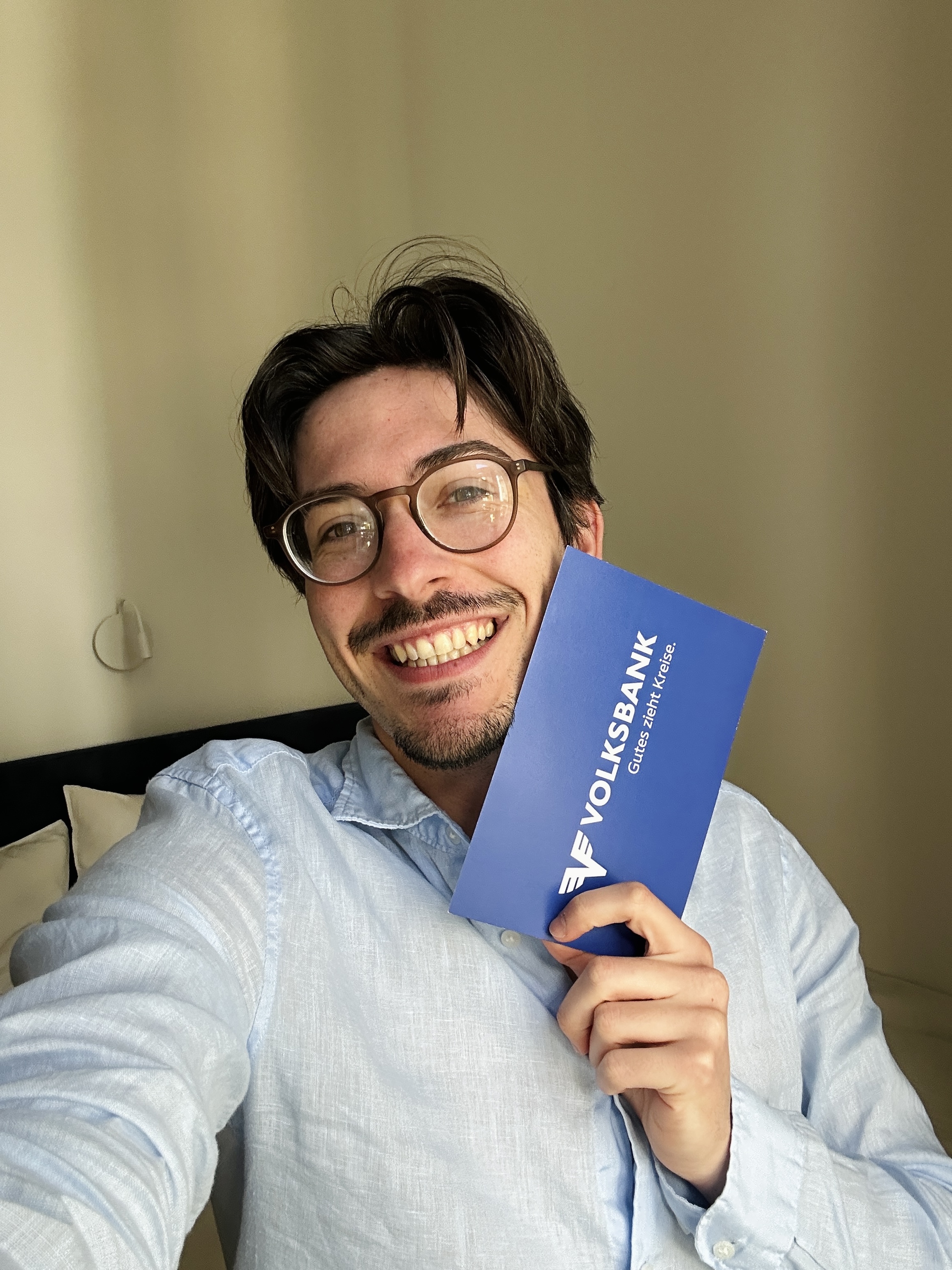Francesco hält seine Volksbank-Goodie Box neben sein Gesicht und strahlt in die Kamera.